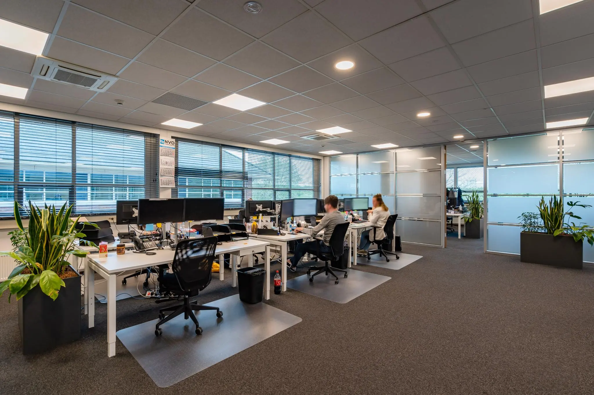 Modern kantoorinterieur aan de 1e Barendrechtseweg met werkplekken, computers en medewerkers aan het werk.